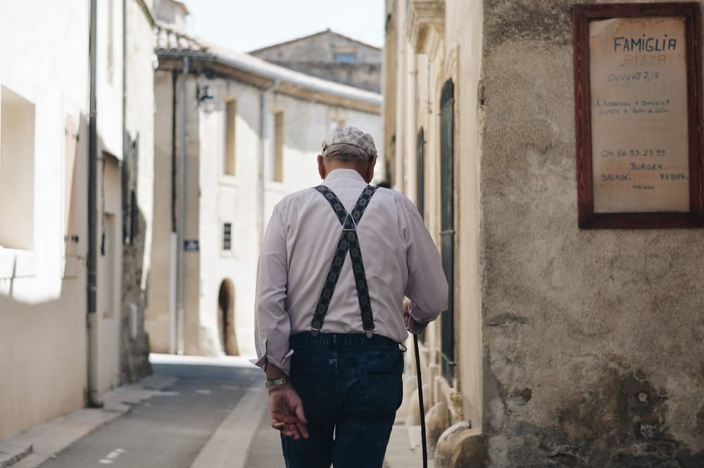 older man walking street in Italy
