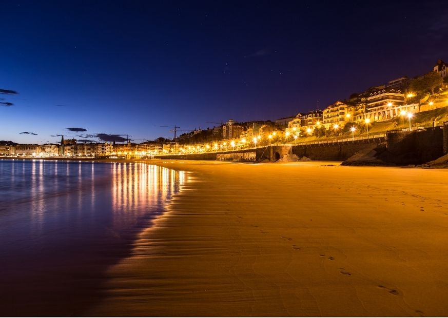 evening beach in spain with lights of houses and shops glowing