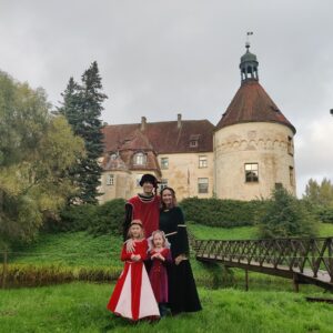 family dressed up in front of castle