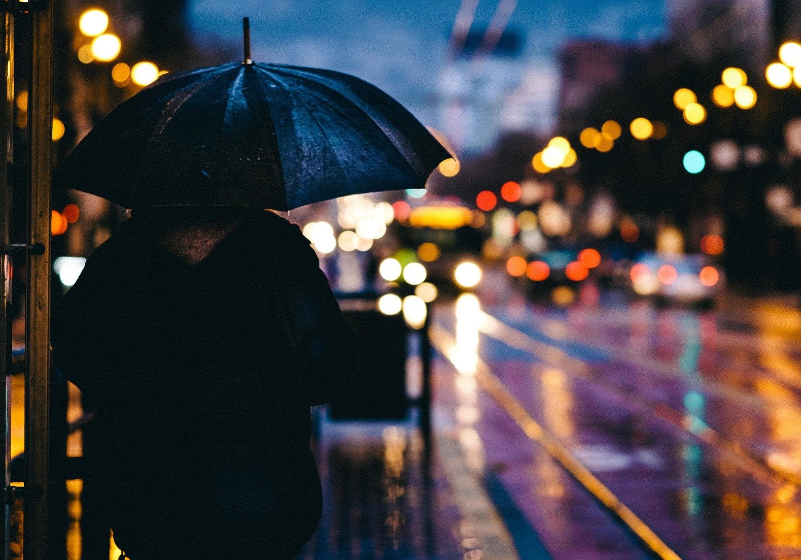 person holding umbrella in rain